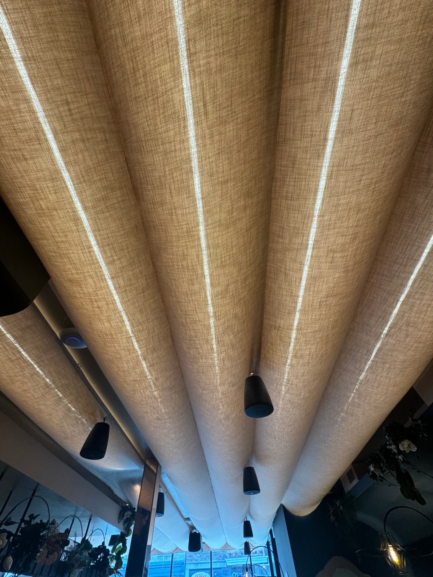 Plafond tendu en lin naturel avec panneaux capitonnés, projet commercial de restaurant à Montréal