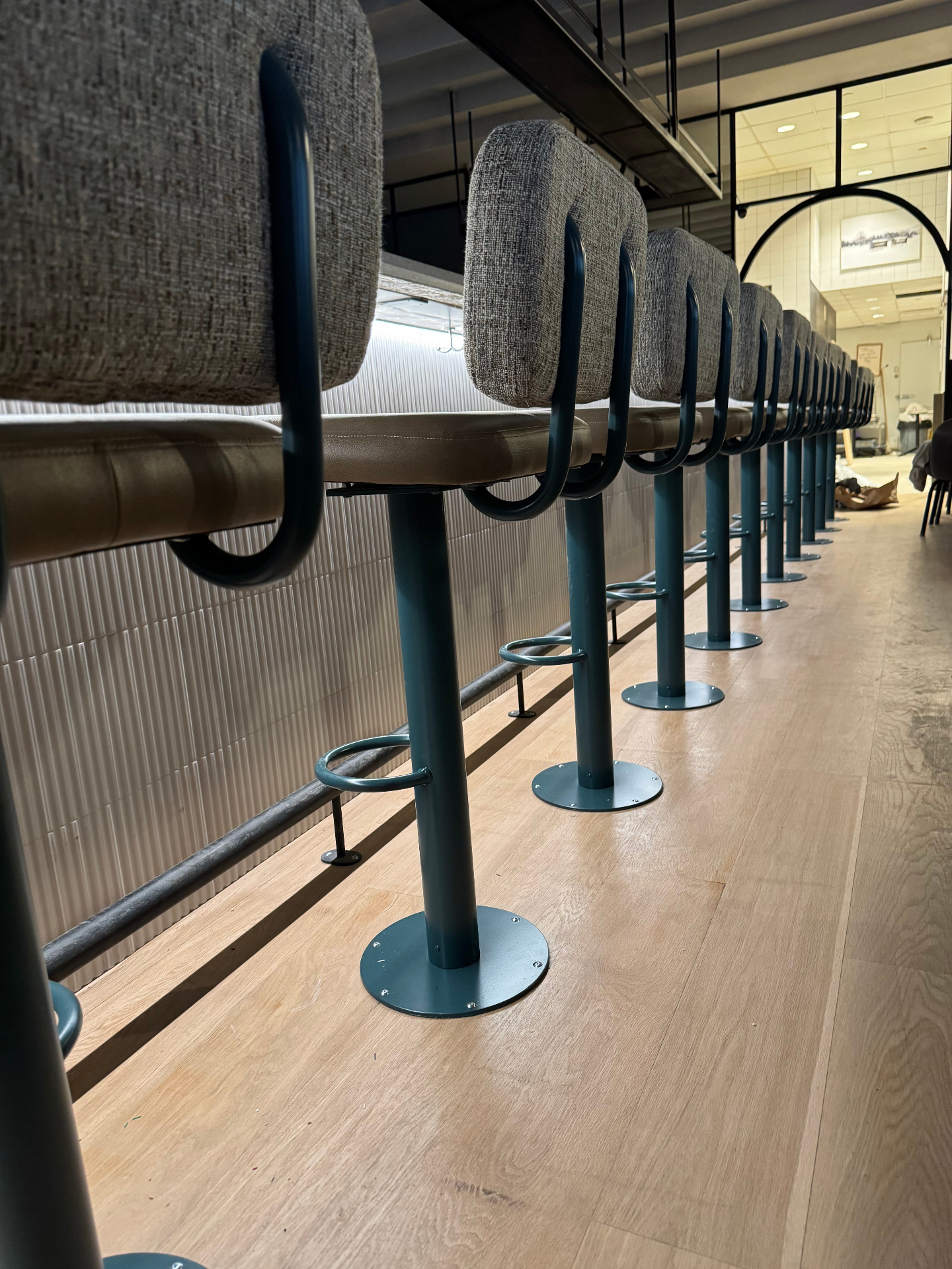 Alignement de tabourets de bar rembourrés sur mesure dans un restaurant montréalais