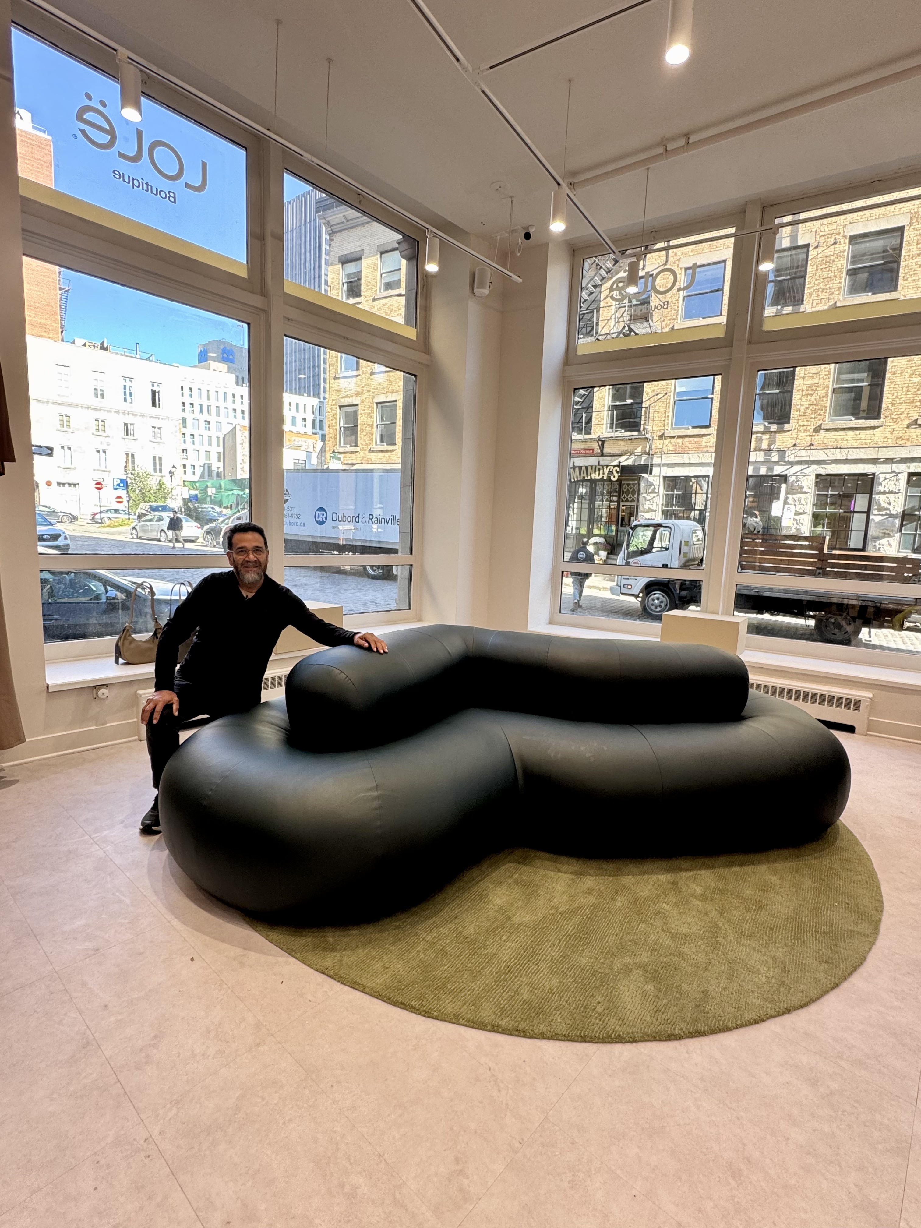 Banquette organique en cuir vert foncé réalisée par l'atelier, installée dans la boutique LOVÉ à Montréal