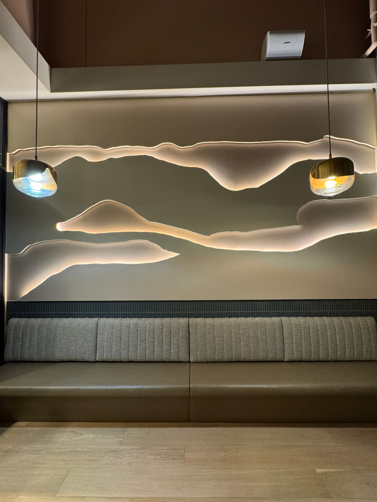 Banquette nervurée grise avec assise en cuir dans un lounge, mobilier sur mesure Montréal